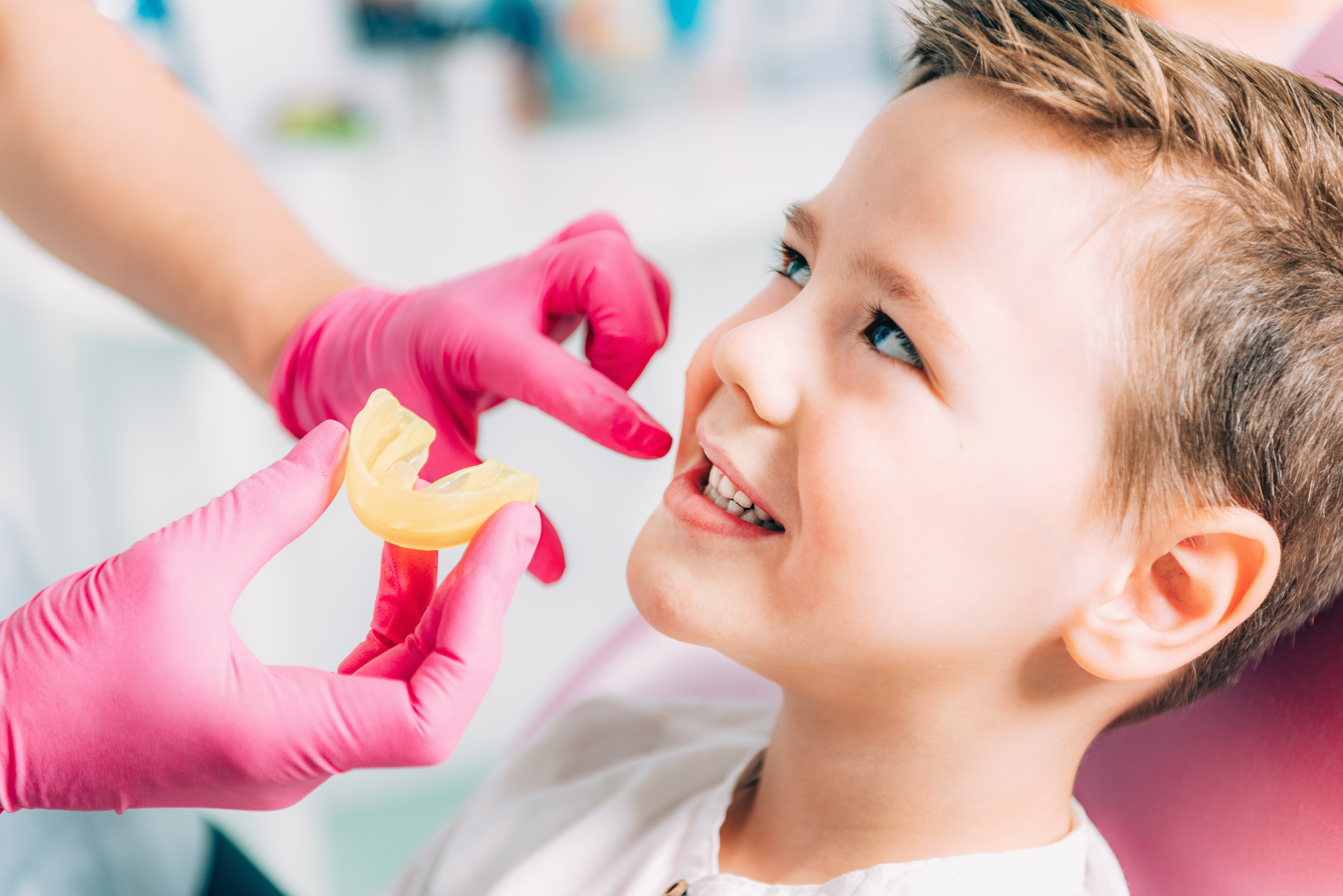 Ortodonta zakłada aparat dziecku z krzywymy zębami od smoczka